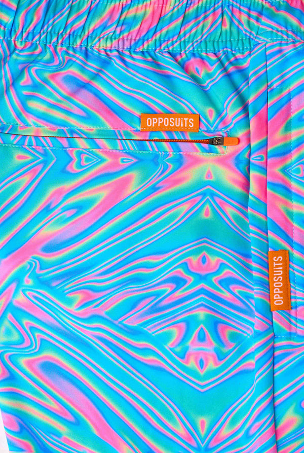 Man wearing a men's vibrant holographic swim shorts with a mesmerizing blue, pink, and purple swirl design. Eye-catching and stylish swimwear for summer fun. Close-up back pocket.