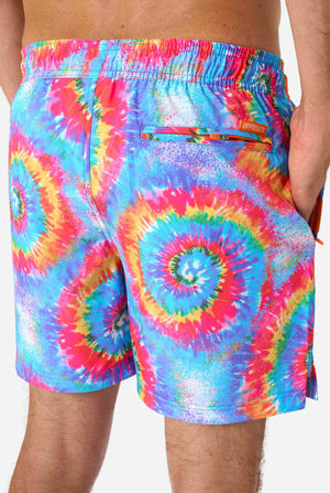Man wearing a men's rainbow tie-dye swim shorts with a bold, colorful spiral pattern. A fun and trendy choice for beach days and pool parties.Man wearing a men's rainbow tie-dye swim shorts with a bold, colorful spiral pattern. A fun and trendy choice for beach days and pool parties. Close -up from the back.