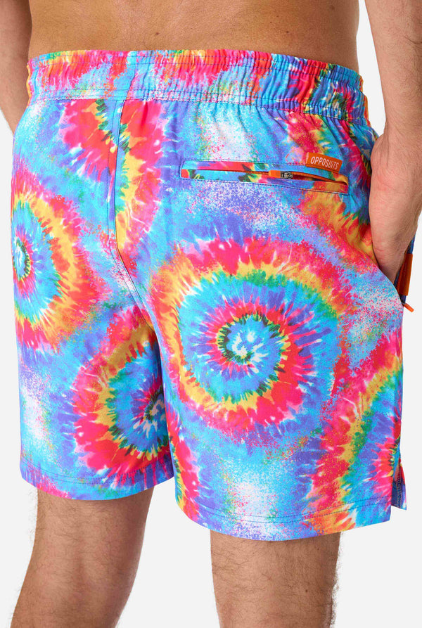 Man wearing a men's rainbow tie-dye swim shorts with a bold, colorful spiral pattern. A fun and trendy choice for beach days and pool parties.Man wearing a men's rainbow tie-dye swim shorts with a bold, colorful spiral pattern. A fun and trendy choice for beach days and pool parties. Close -up from the back.