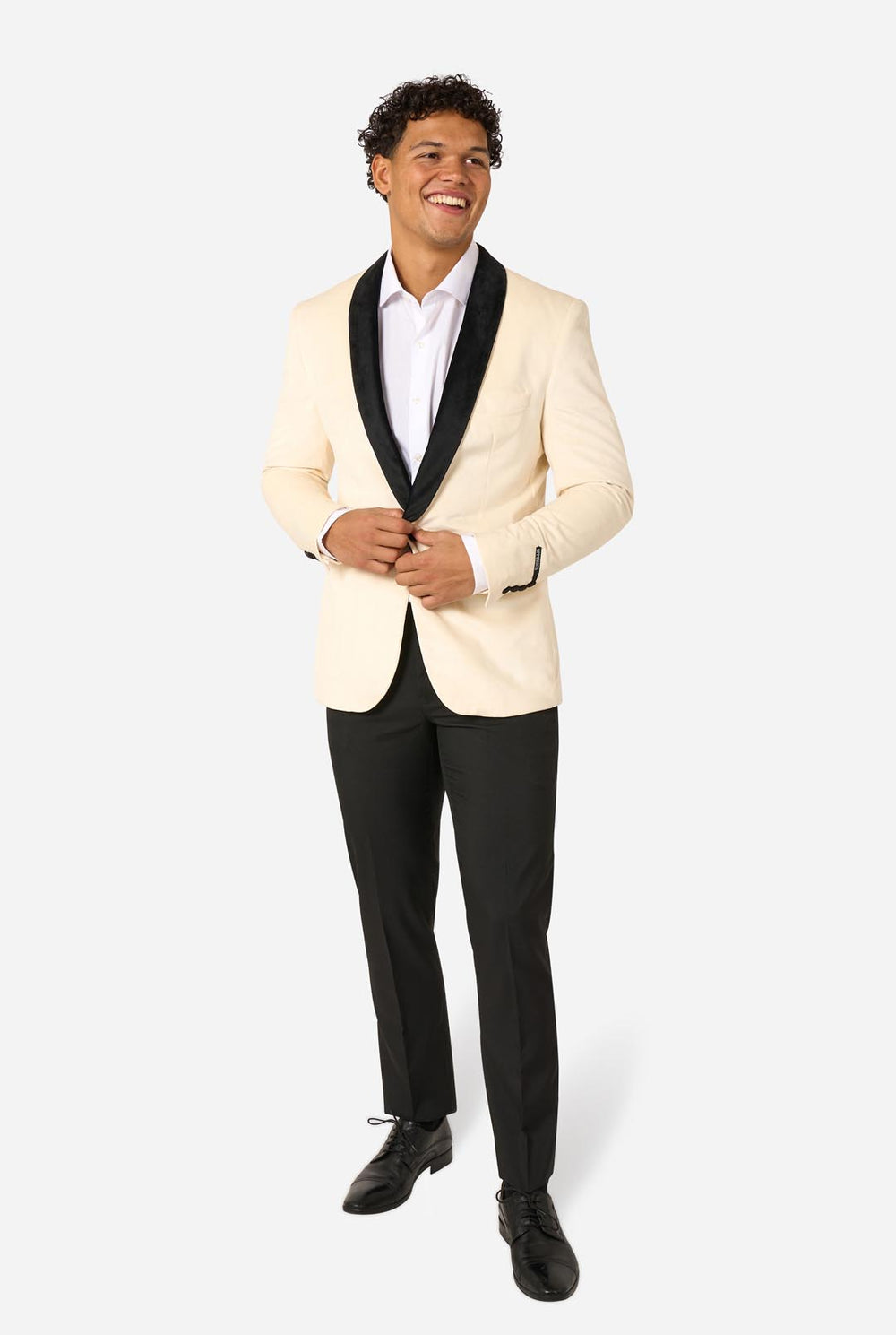 Man wearing a cream blazer with black lapels and trim on a light background