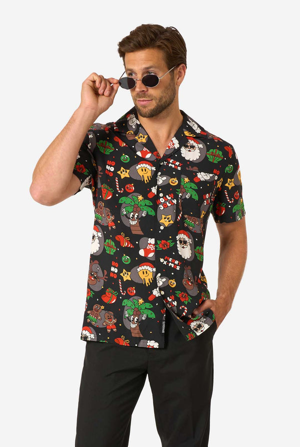 Man wearing a colorful patterned Christmas shirt and sunglasses with a white background