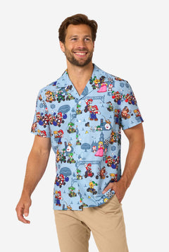 Man wearing a colorful shirt with Mario character patterns on a light gray background