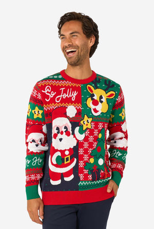 Smiling man wearing a colorful knitted Christmas sweater featuring Santa Claus, Rudolph, and the text “So Jolly.”