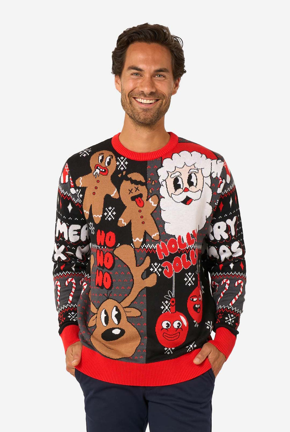 Smiling man wearing a black and red knitted Christmas sweater featuring Santa, reindeer, gingerbread men, and festive ornaments.