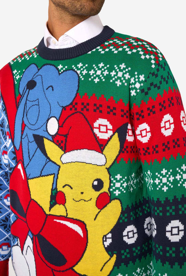 Close-up of the knitted Christmas sweater’s front showing Pikachu, blue Pokémon, and a large red bow on a festive background.