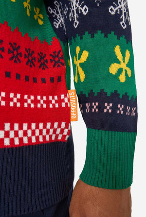 Detail of the knitted Christmas sweater hem with red, green, and navy patterns and an orange “Opposuits” label.