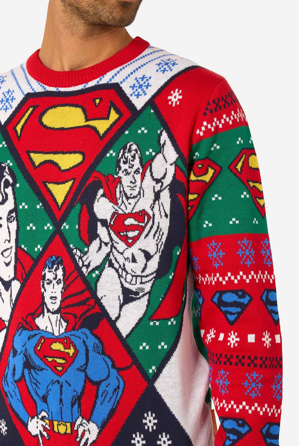 Close-up of the knitted Christmas sweater showing detailed Superman graphics and holiday motifs.