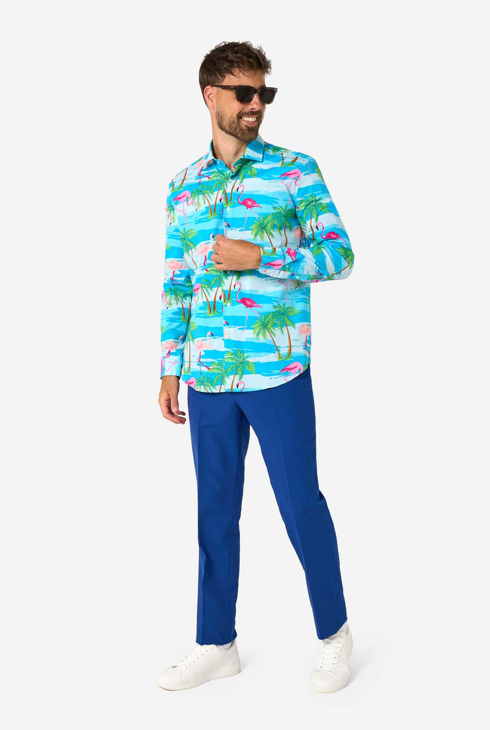 Man wearing a colorful tropical shirt with flamingos and palm trees on a white background