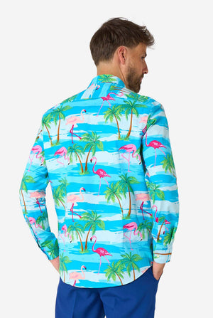 Man wearing a colorful shirt with flamingo and palm tree pattern on a white background, view from the back.