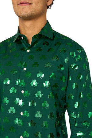 Man wearing a green clover-patterned St. Patrick's Day shirt on a light background. Chest close up.