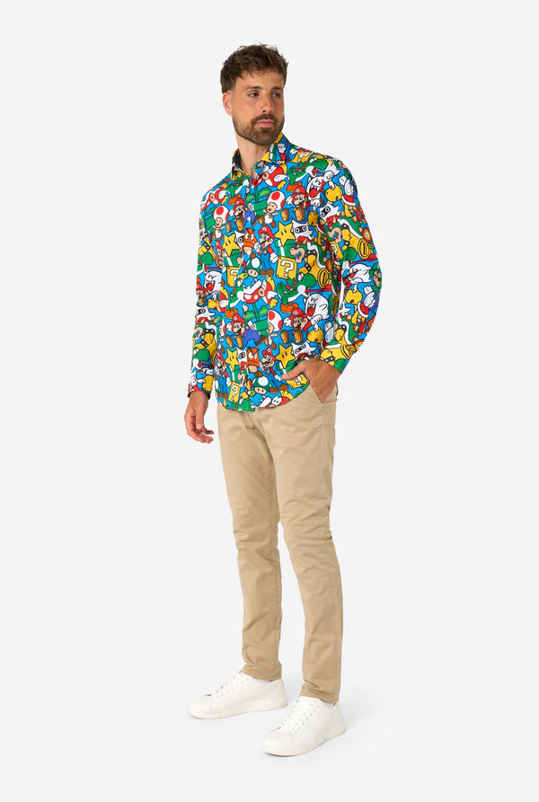 Man wearing a colorful shirt with Super Mario characters pattern and a beige pants on a white background.