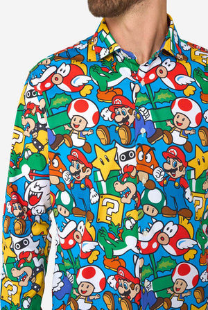 Man wearing a colorful shirt with Super Mario characters pattern on a white background. Chest close up.