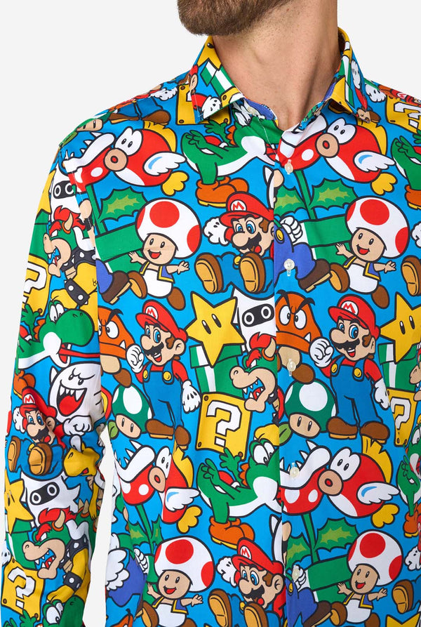 Man wearing a colorful shirt with Super Mario characters pattern on a white background. Chest close up.