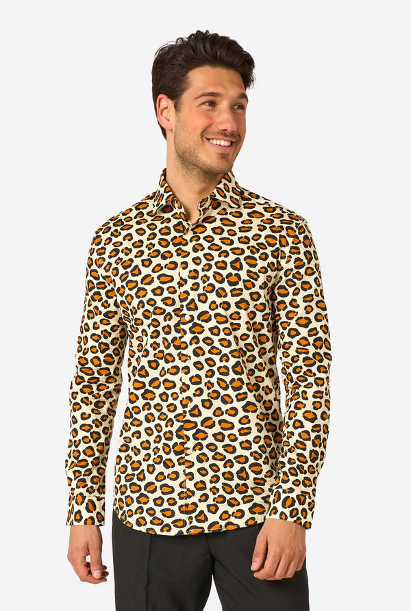 Image of a man wearing a beige shirt covered with panther spots, and wearing black pants. 