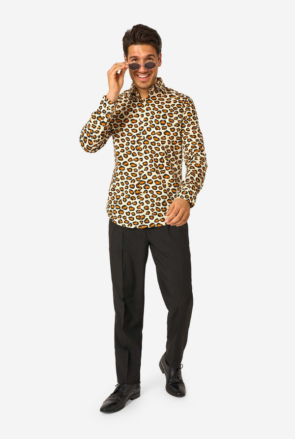 Image of a man wearing a beige shirt covered with panther spots, and wearing black pants. Full body image