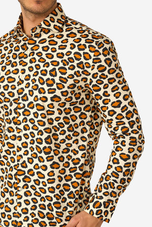 Image of a man wearing a beige shirt covered with panther spots. Chest close-up.