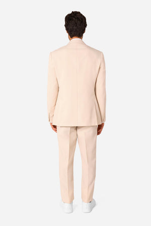 Image of a man wearing a sand colored beige suit and a white shirt. View from the back.