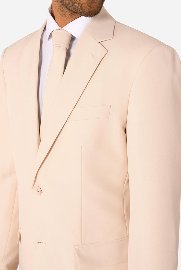 Image of a man wearing a sand colored beige suit and a white shirt. Chest close-up.