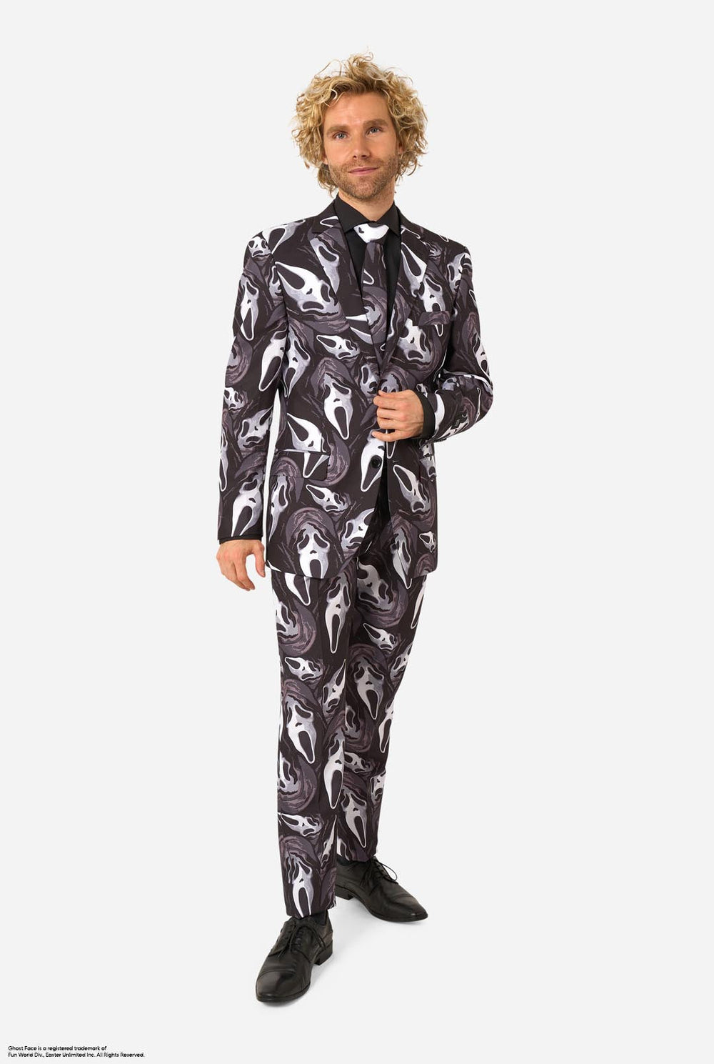 A man modeling a Ghostface-themed suit with a black, white, and gray mask pattern, a black shirt, a bow tie.
