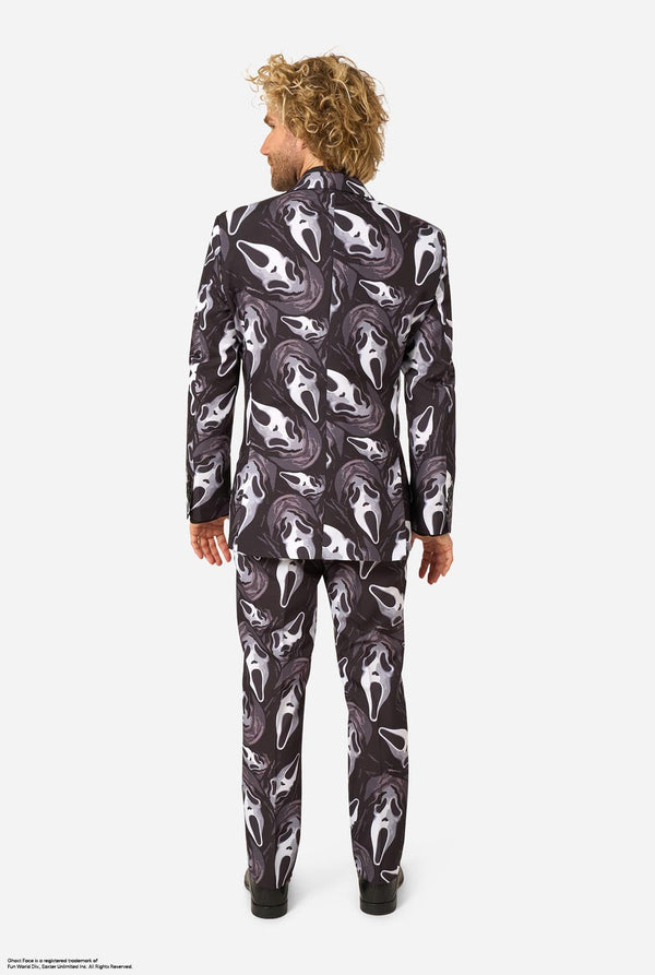 A man modeling a Ghostface-themed suit with a black, white, and gray mask pattern, a black shirt, a bow tie. View from the back.