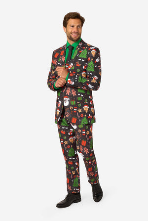 A man poses in a black background colored christmas suit decorated with festive holiday imagery like reindeer, snowflakes, and gift boxes. Full body image