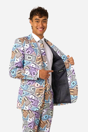 Image of a man wearing a men's suit with an all over print from Monopoly money. He is also wearing a white men's shirt. Holding one side of the jacket open.