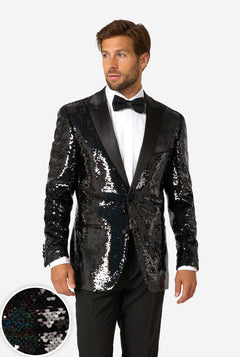 A man modeling a black sequined tuxedo jacket with black satin lapels, worn over a white dress shirt and black bow tie, against a light gray studio background. A circular inset at the lower left shows a close-up of the black sequin texture.