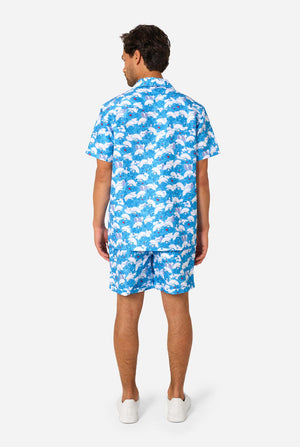 Man wearing a blue and white Smurfs patterned shirt and shorts on a light background. View from the back.