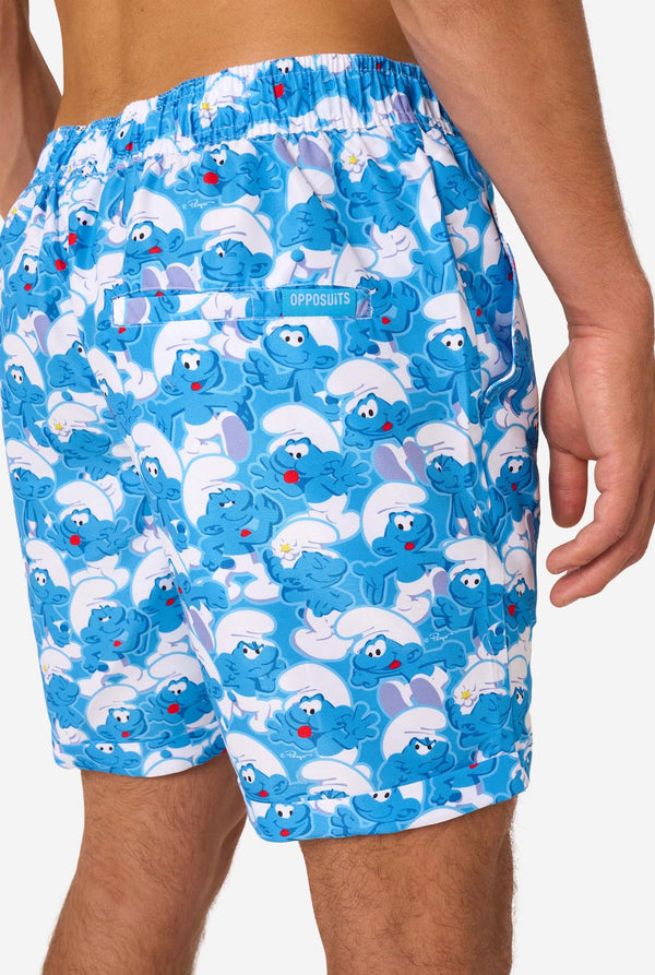 Man wearing a blue and white Smurfs patterned shirt and shorts on a light background. Shorts close-up.