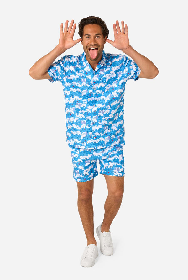 Man wearing a blue and white Smurfs patterned shirt and shorts on a light background. Full body image 2.