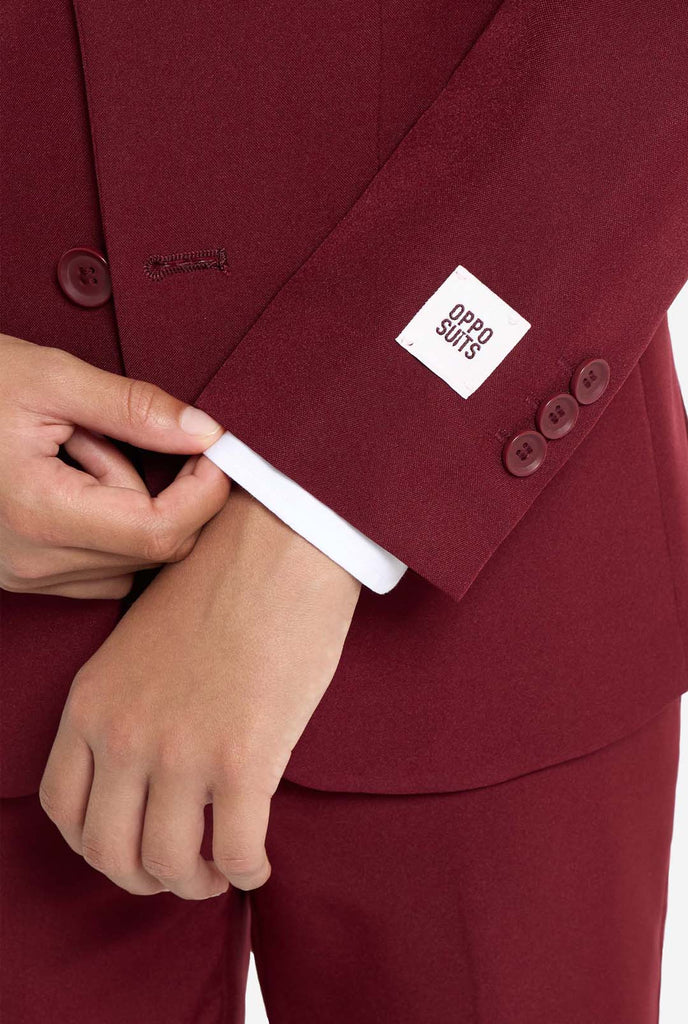 Teen wearing formal burgundy red suit, close up sleeve