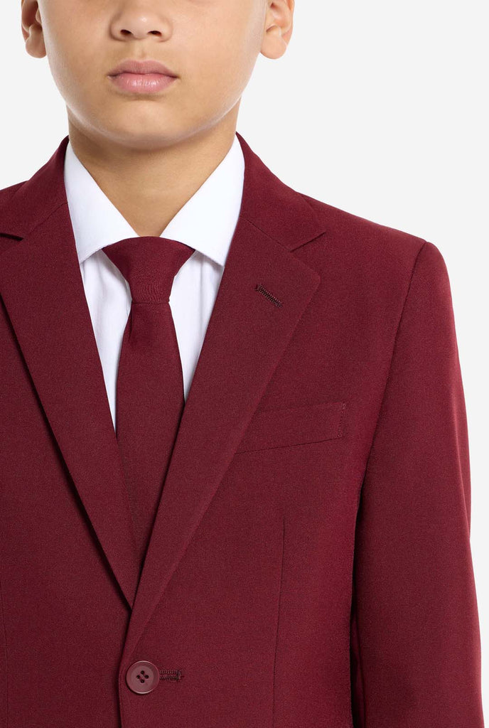 Teen wearing formal burgundy red suit, close up chest