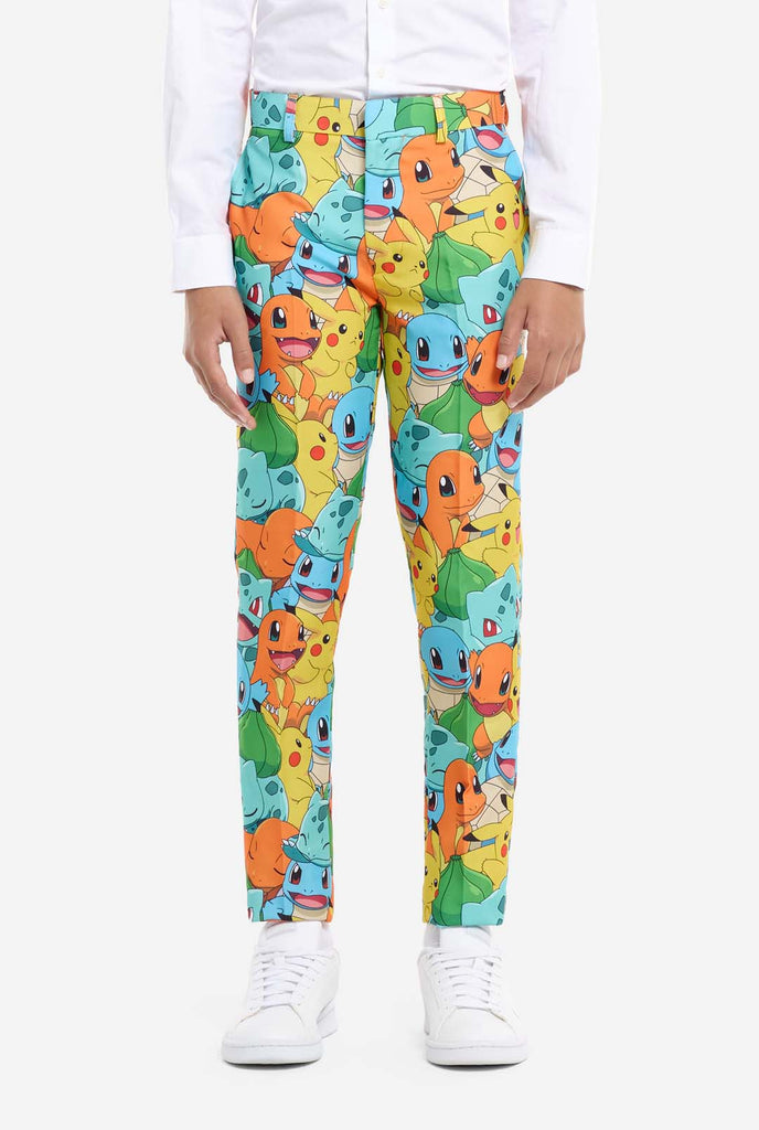 Teen wearing formal multi color suit with all-over Pokemon print. The suit contains the characters Pikachu, Bulbasaur, Charmander and Squirtle. Pants view.