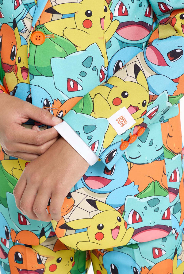 Teen wearing formal multi color suit with all-over Pokemon print. The suit contains the characters Pikachu, Bulbasaur, Charmander and Squirtle. Sleeve close up.