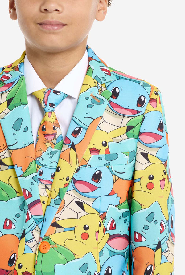 Teen wearing formal multi color suit with all-over Pokemon print. The suit contains the characters Pikachu, Bulbasaur, Charmander and Squirtle. Chest close up.