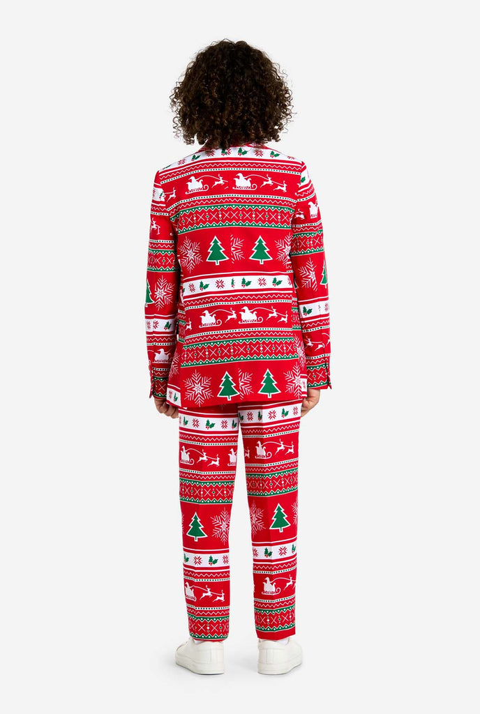 Teen wearing red Christmas suit with green and white Christmas icons, like Christmas tree, snowflakes, holly and sled with reindeers. View from the back.