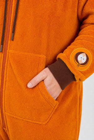 Close-up of the Kenny onesie showing the orange fleece fabric, front pocket and character sleeve patch.