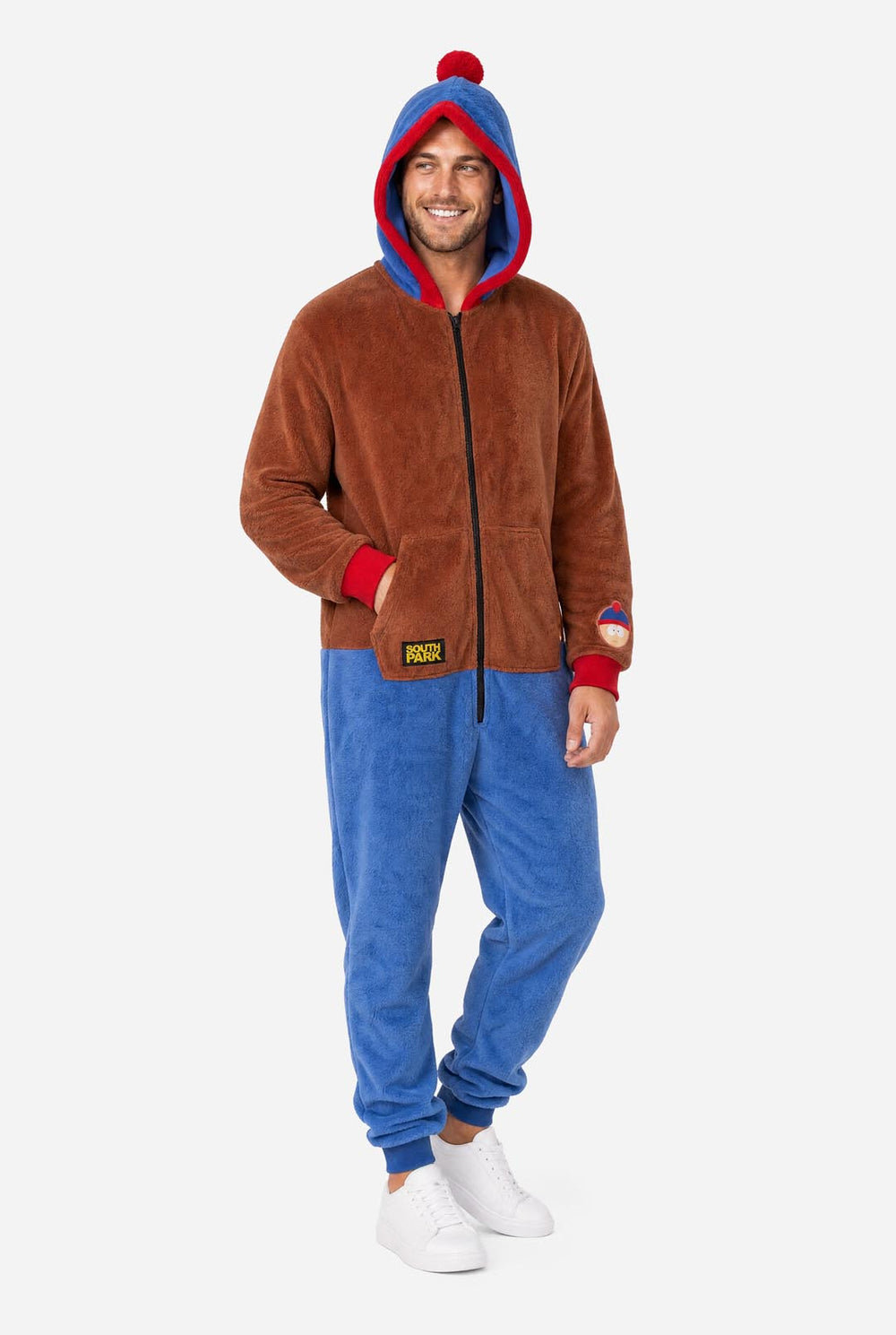 Male model wearing a brown and blue South Park Stan adult onesie with blue and red hood.