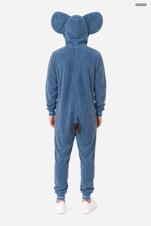 A person viewed from the back wearing a blue plush animal onesie with large ears on the hood and a small tail at the back, paired with white sneakers, against a light gray studio background.