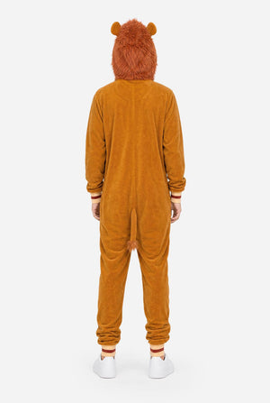 A man wearing a plush lion onesie pajama with a hood featuring a lion face and ears, a tan belly patch, and a red patterned hood lining, against a white background. View from the back.