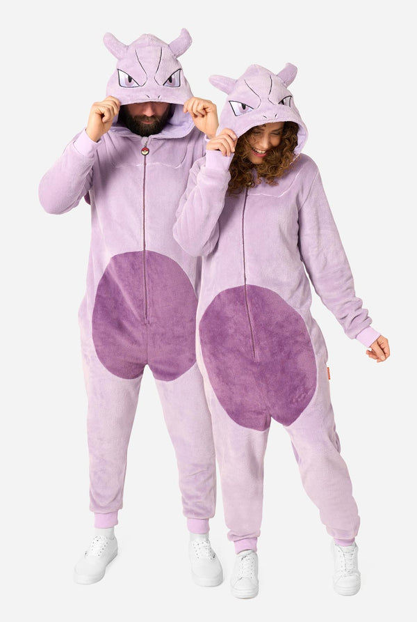 Two models wearing matching light purple plush kigurumi onesies with darker purple circular patches and hooded Mewtwo faces, standing against a plain light gray background.