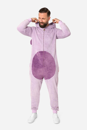 A man modeling a light purple full-zip hooded onesie with a darker purple circular patch on the front, posed against a solid light gray background.