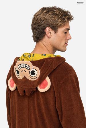 A man wearing a brown plush monkey costume hoodie, shown from the back and side profile against a light gray background.