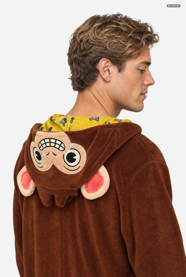 A man wearing a brown plush monkey costume hoodie, shown from the back and side profile against a light gray background.