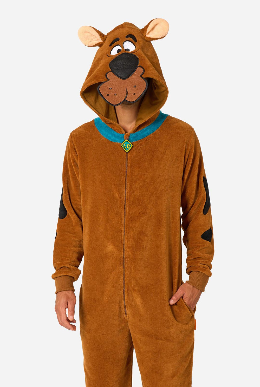 A person wearing a brown Scooby-Doo-themed hooded onesie costume with a blue collar trim and black patch details, photographed against a light gray studio background.