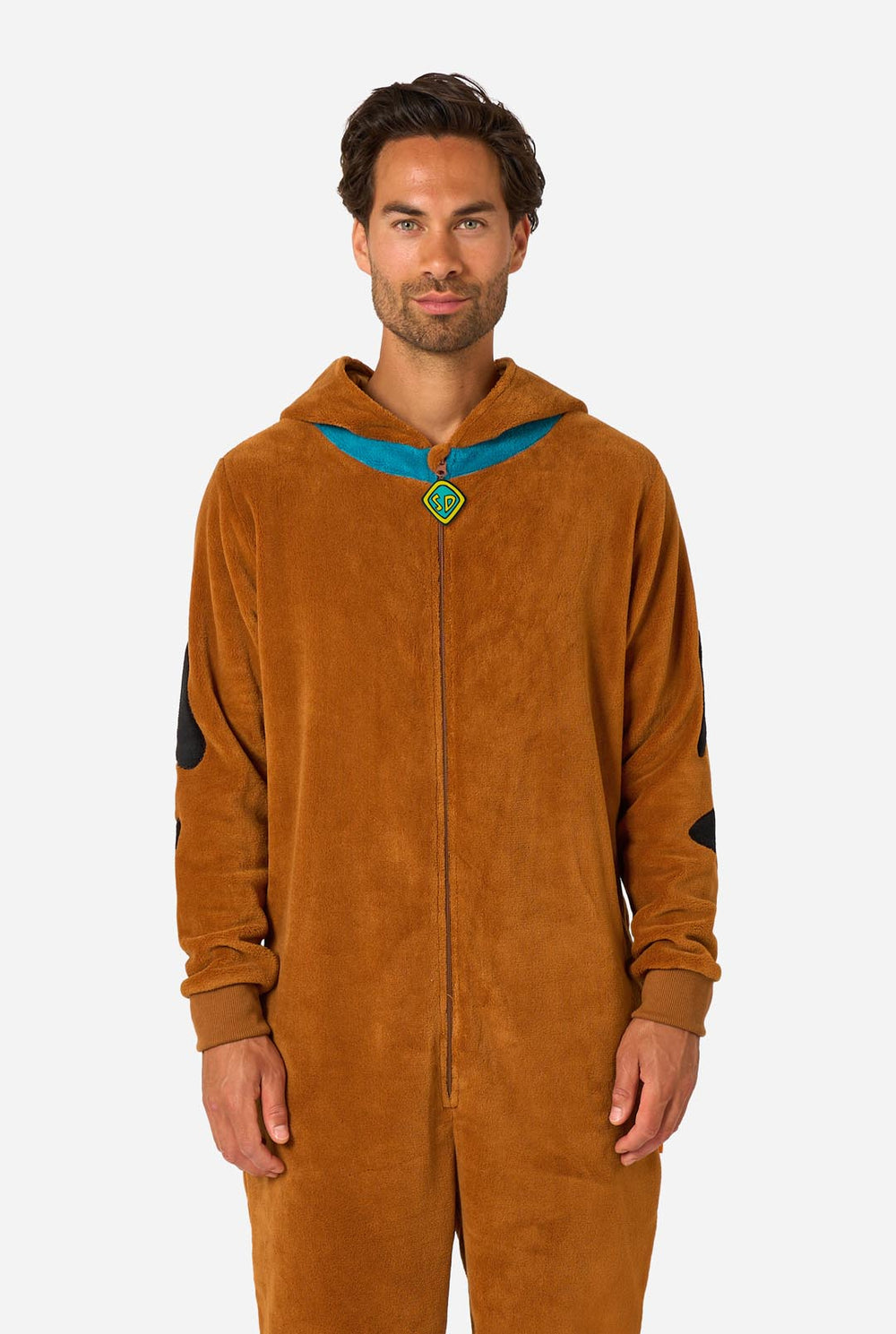 A person wearing a brown Scooby-Doo-themed hooded onesie costume with a blue collar trim and black patch details, photographed against a light gray studio background.