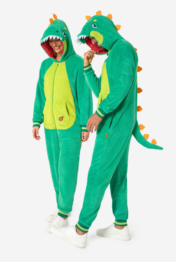A man and woman are wearing a green dinosaur adult onesie featuring playful hood details and cozy, soft material, perfect for lounging or costume events. Full body image.