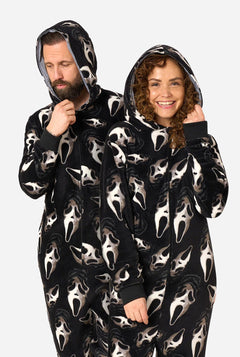A man and a woman wearing matching black hooded onesies with an all-over Ghostface mask print, posed against a light gray studio background.