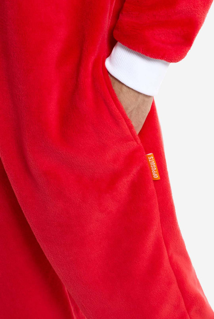 A person wears a bright red Knuckles the Echidna adult onesie, a cozy and playful outfit inspired by the famous character from the Sonic the Hedgehog series. The outfit, made from soft fleece material, is perfect for lounging, cosplay, or themed events, offering both comfort and style. Close up from side pocket with hand in pocket.