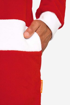 A smiling man models a cozy, red and white, hooded christmas onesie that resembles a Santa onesie. Close up of the pockets